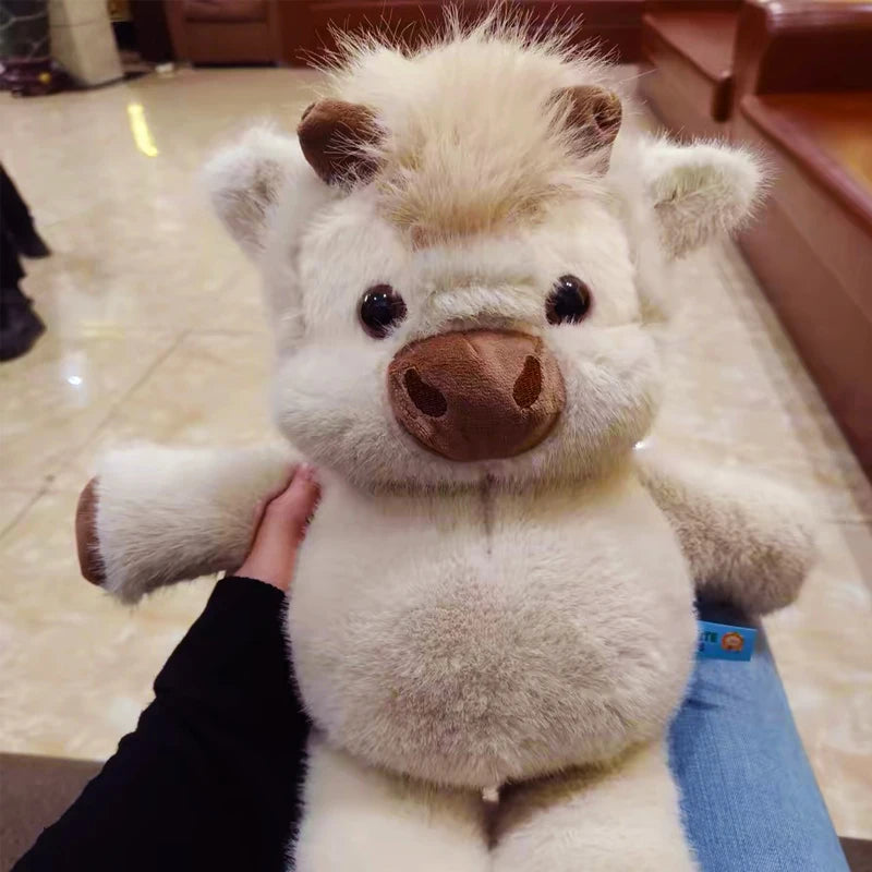 Vaca Highland de peluche de pelo largo en brazos
