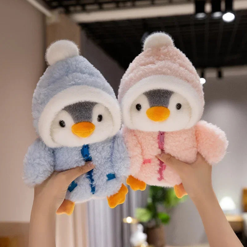 Pingüinos de peluche azul y rosa en las manos
