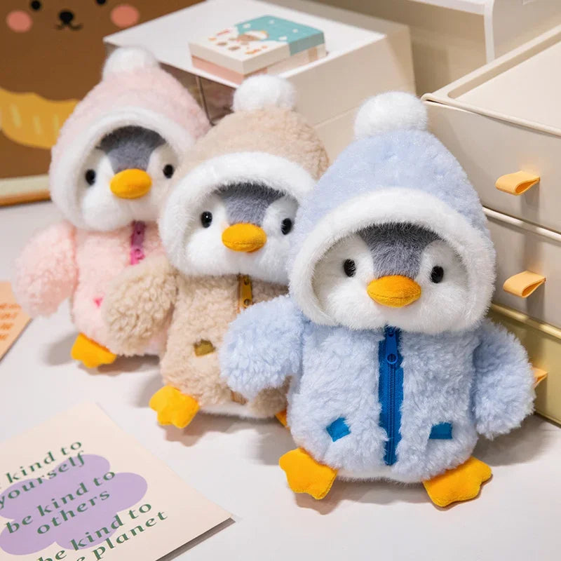 Tres pingüinos de peluche con abrigo de borreguito
