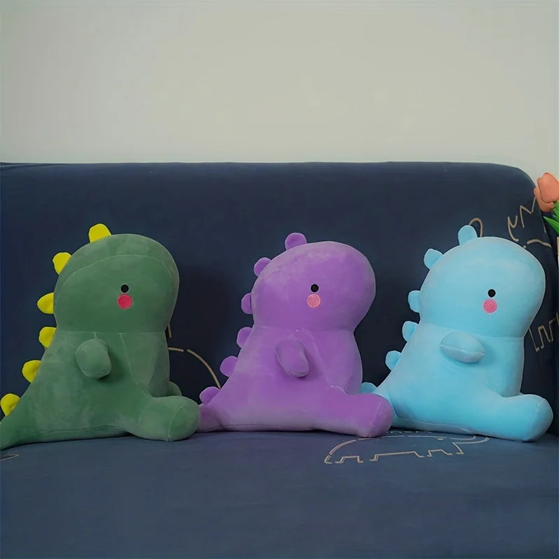 Tres dinosaurios de peluche en fila